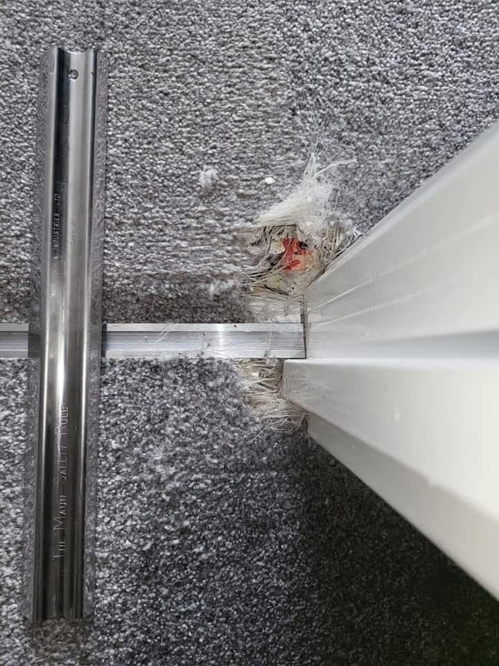 Matted carpet fibres at door threshold before cleaning