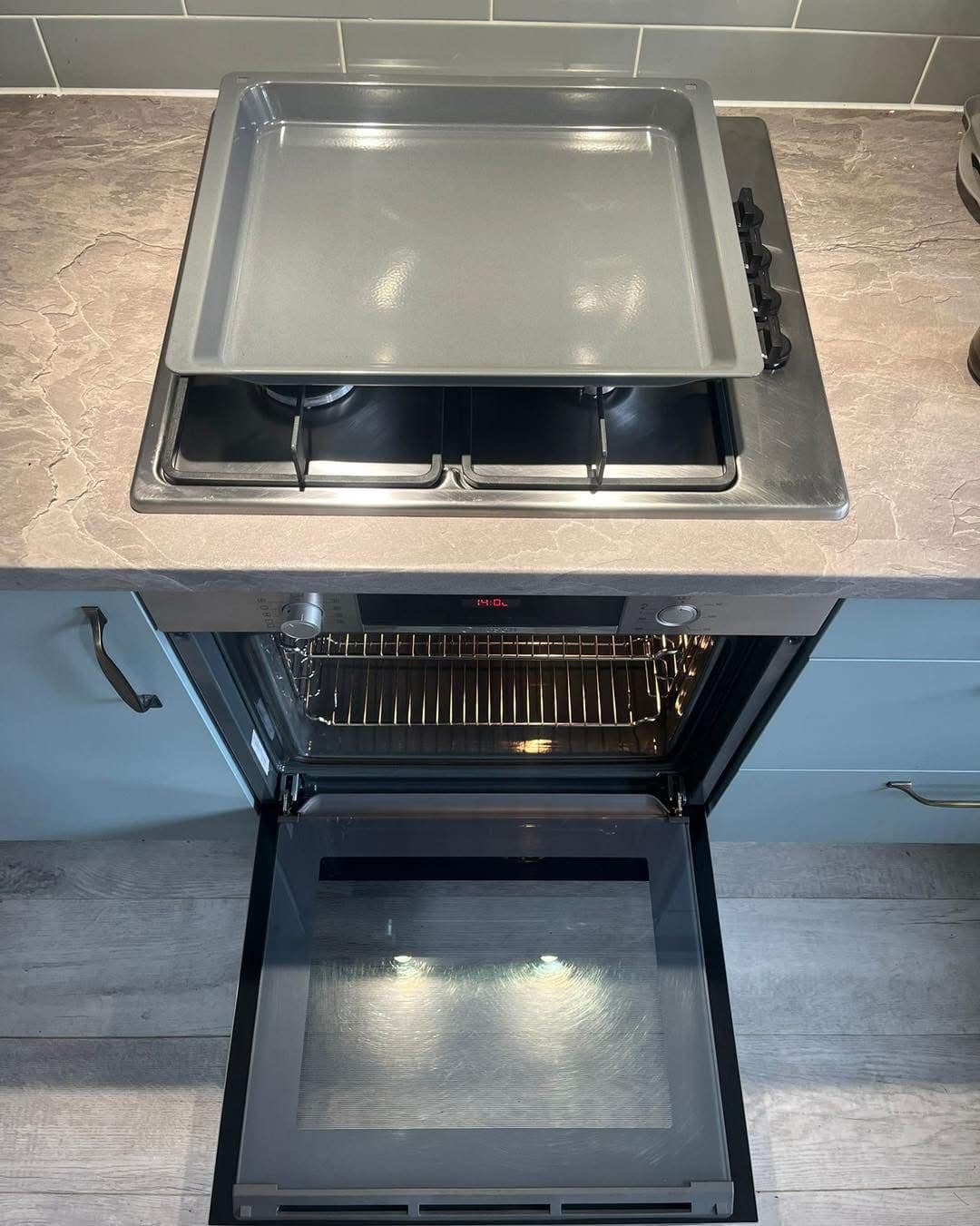 Clean range oven and hob with gleaming baking tray after cleaning