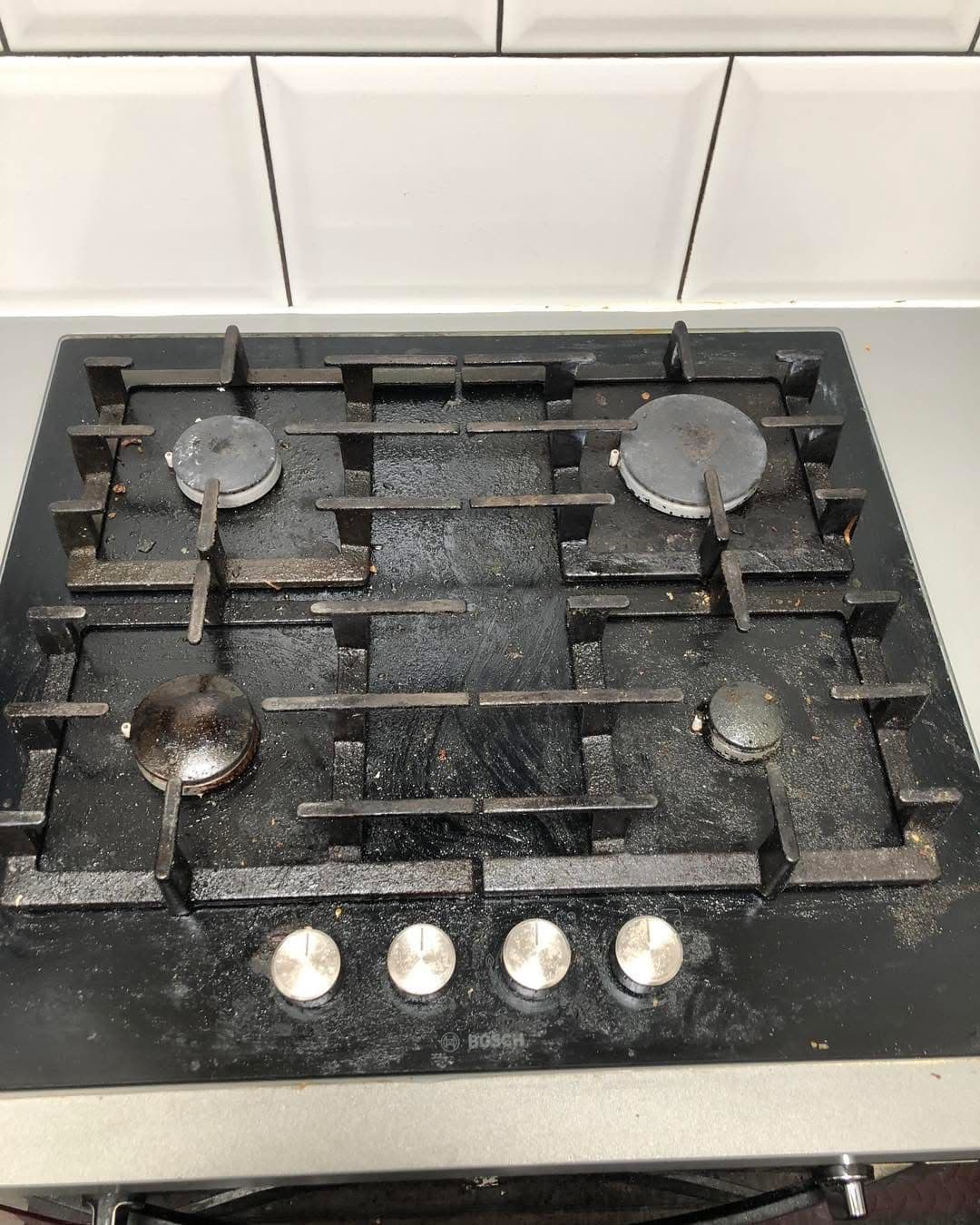 Dirty black Bosch 4-burner gas hob before cleaning