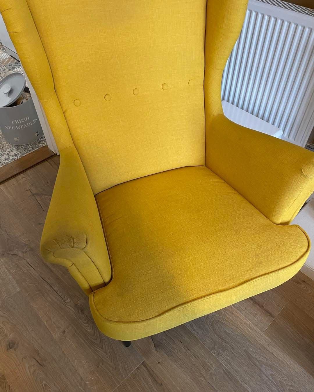 Restored yellow wingback chair after professional upholstery clean